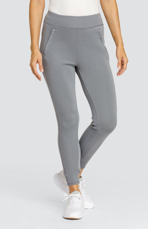 Model wearing a gray ankle length jogger with a waistband, welt pockets, and ribbed back ankle cuffs.