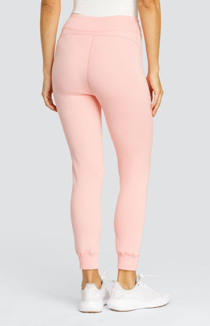 Model wearing a light pink ankle length jogger with a waistband, welt pockets, and ribbed back ankle cuffs.