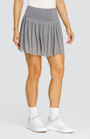 Model wearing a gray mesh pleated skort with solid waistband and undershorts.