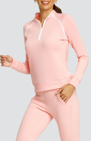 Model wearing a light pink long sleeve sweatshirt with a quarter zip neckline, white piping accents, and ribbed hem and cuffs. Paired with a matching jogger with welt pockets.