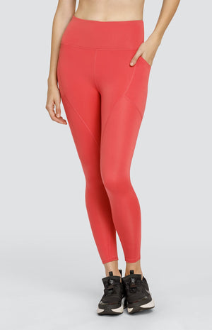 Model wearing coral high rise leggings with side pockets.