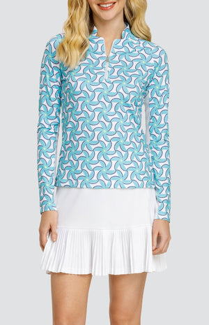 Model wearing a long sleeve top with spiral floral pattern in turquoise and blue on a white background, and a solid white skort.