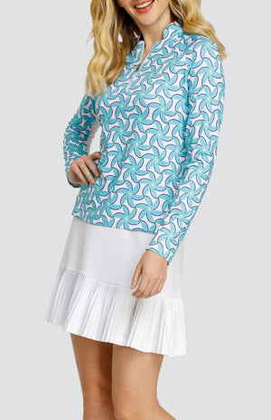 Model wearing a long sleeve top with spiral floral pattern in turquoise and blue on a white background, and a solid white skort.