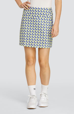 Model wearing a pull-on golf skort with a geometric circular pattern in blue and yellow on a white background.