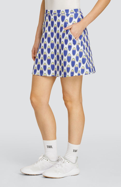 Model wearing a pull-on golf skirt with an oval pattern in blue and yellow on a white background.