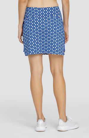 Model wearing a pull on skort with a blue and white lattice pattern with blue side inserts.