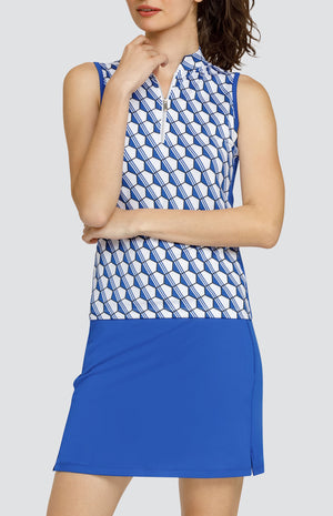 Model wearing a sleeveless golf top with a blue and white hexagon pattern, and a blue skort.