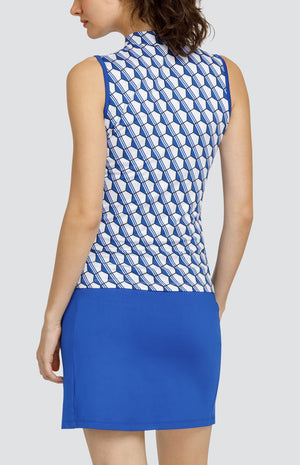 Model wearing a sleeveless golf top with a blue and white hexagon pattern, and a blue skort.