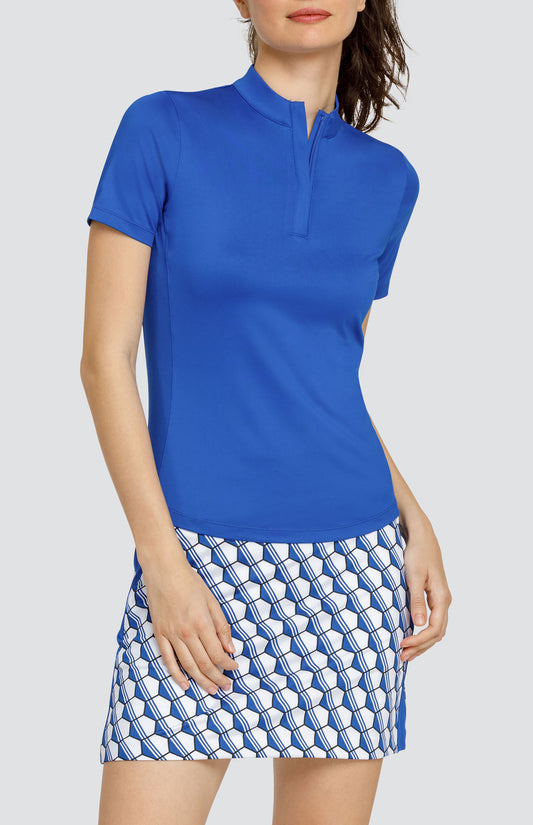 Model wearing a short sleeve solid blue top and a skort with a blue and white hexagon pattern.