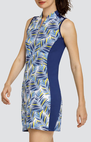 Model is wearing a performance jersey, sleeveless dress with a Mandarin funnel collar. Dress is in "Melody" print of Lakestorm blue, Dandelion yellow, and Chalk white. Dress has pockets and Chalk white shorties. 