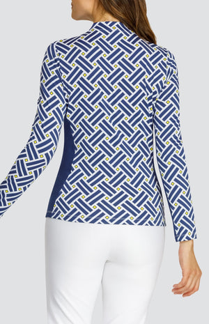 Model wearing a long sleeve quarter zip gold top with a blue criss cross pattern and yellow squares on a white background, with solid white pull on pants.