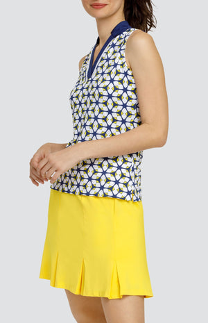 Model is wearing a sleeveless performance jersey top with a novelty collar. The top is in print "Jewel Twist" showing a geometric pattern of Lakestorm blue, Dandelion yellow, and Chalk white. 