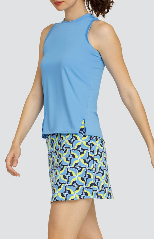 Model wearing a light blue tank top and a skort with light blue and neon yellow abstract grid pattern.