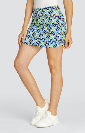 Model wearing a pull on tennis skort with a light blue and neon yellow abstract grid pattern.